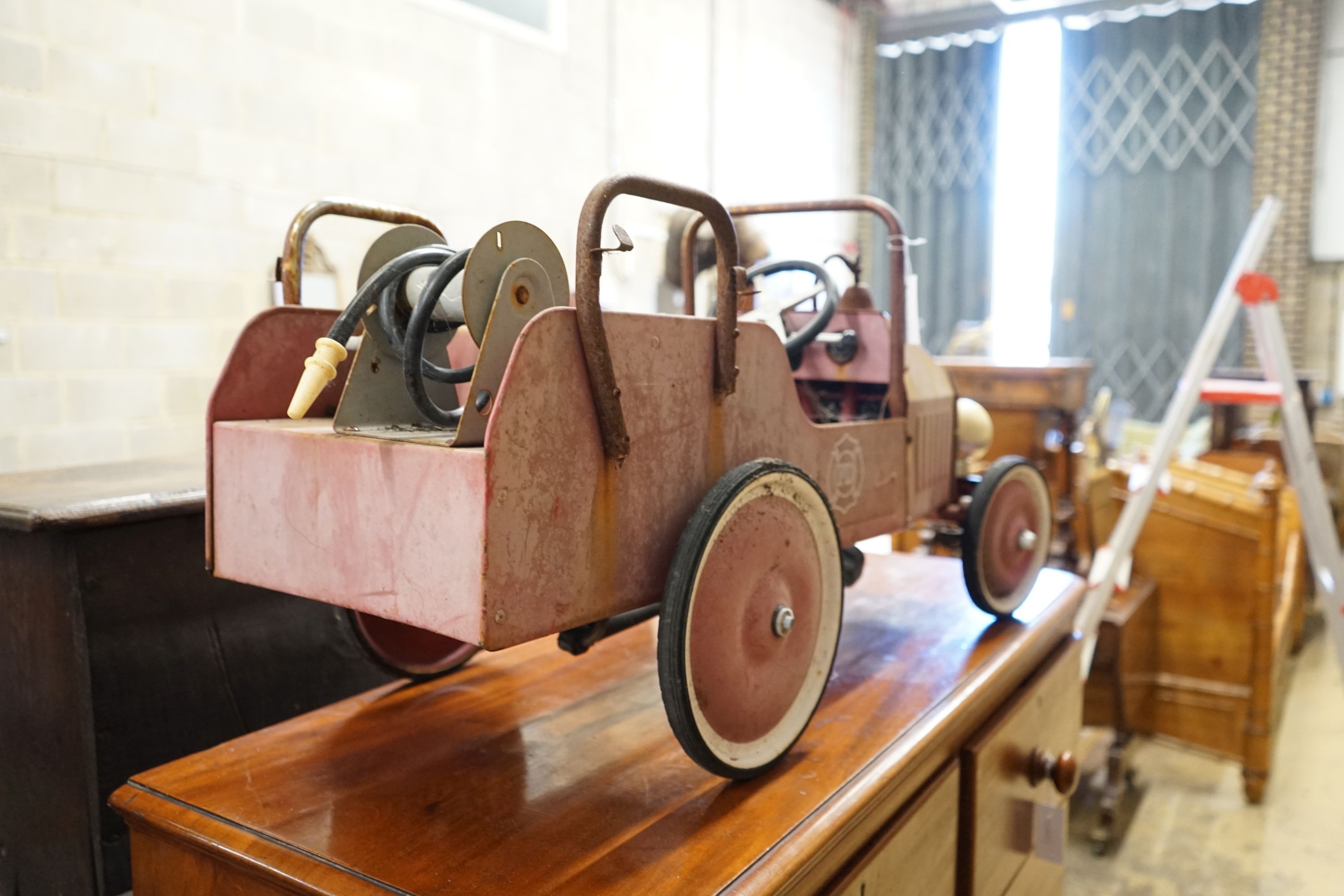 A child's tin plate pedal ride on toy fire engine, length 95cm